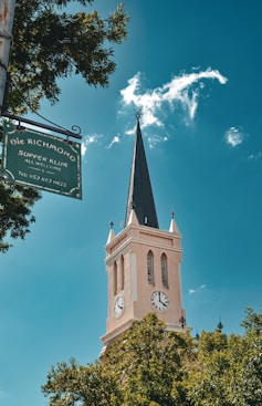 A church steeple with a street sign in front of it