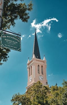 A church steeple with a street sign in front of it