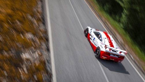 A red and white car driving down a road