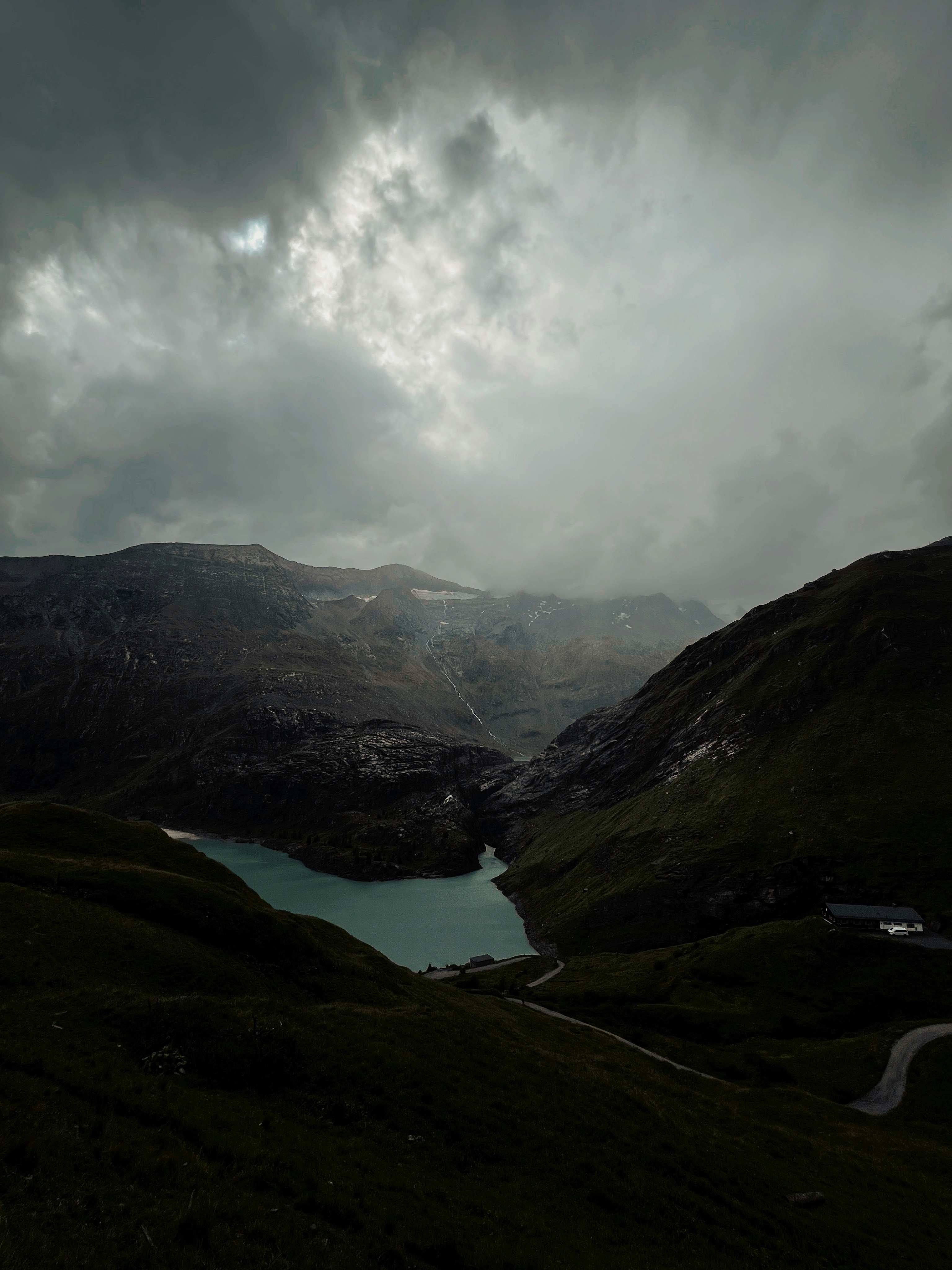A lake surrounded by mountains under a cloudy sky