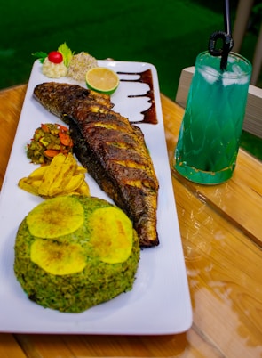 A plate of food on a table with a drink