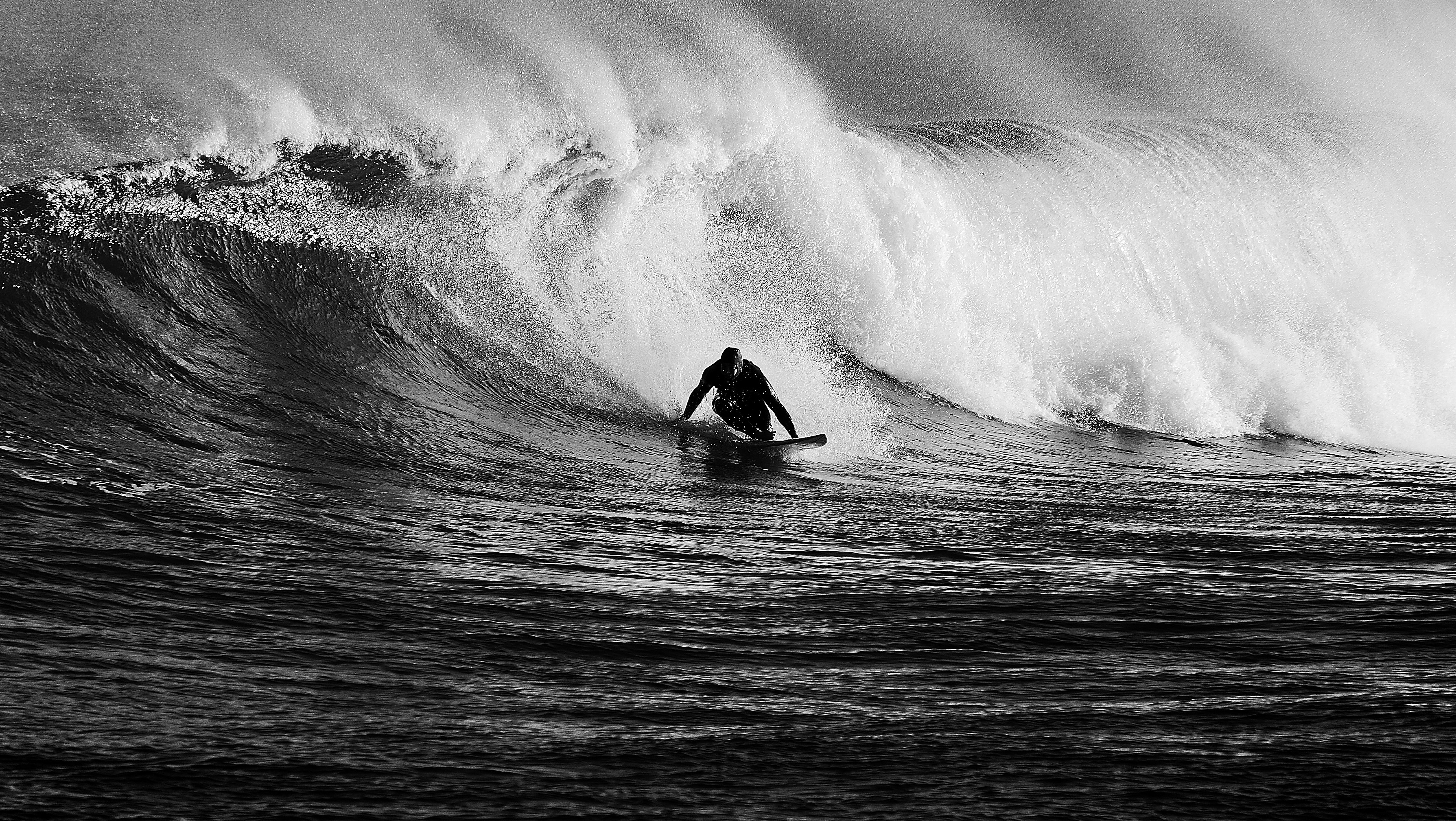 A man riding a wave on top of a surfboard