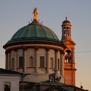 A large building with a clock tower and a statue on top of it