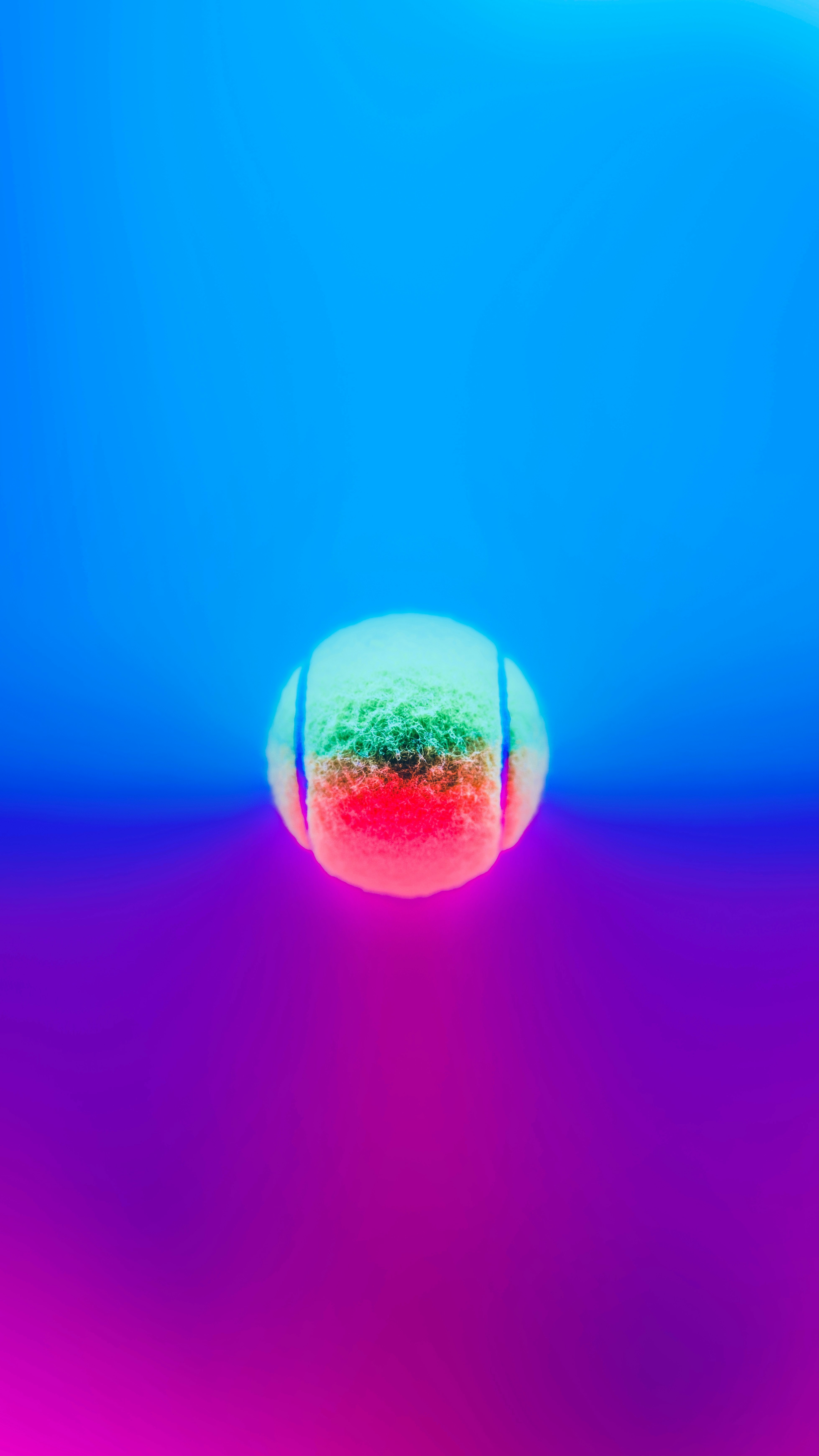 Ein verschwommenes Bild eines Tennisballs auf blauem und rosafarbenem Hintergrund
