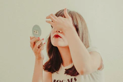 A little girl holding a mirror to her face