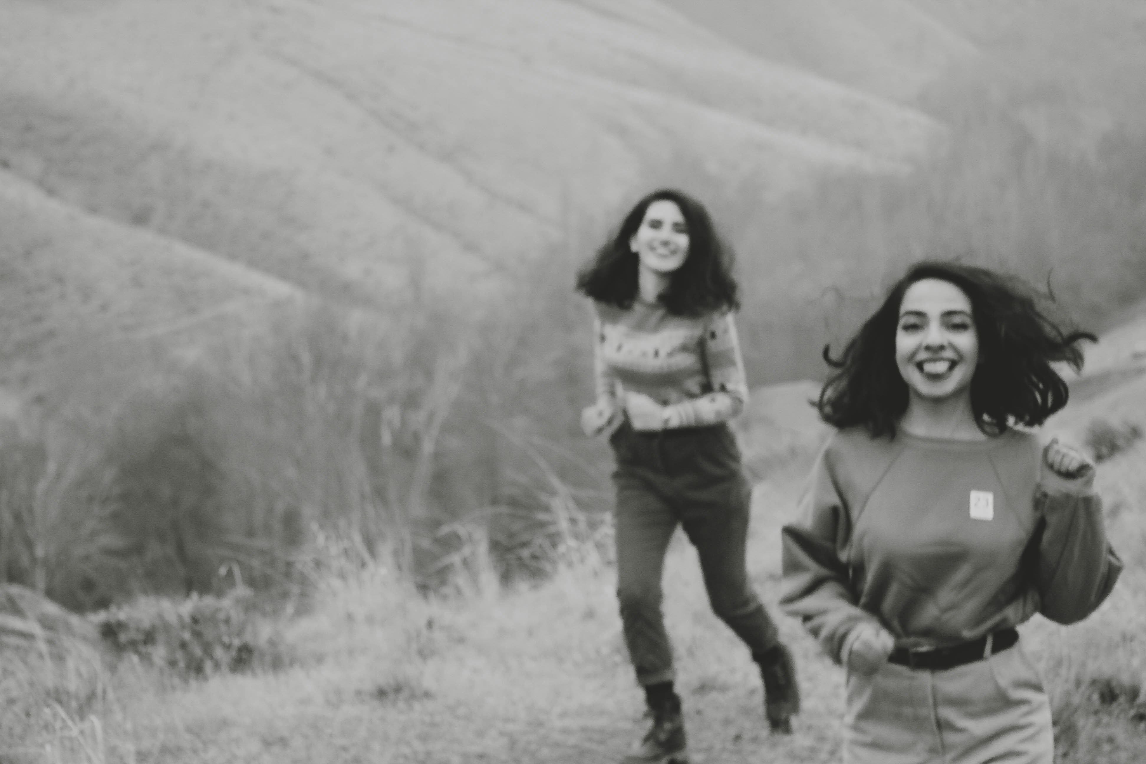 Un couple de femmes marchant dans un champ couvert d’herbe