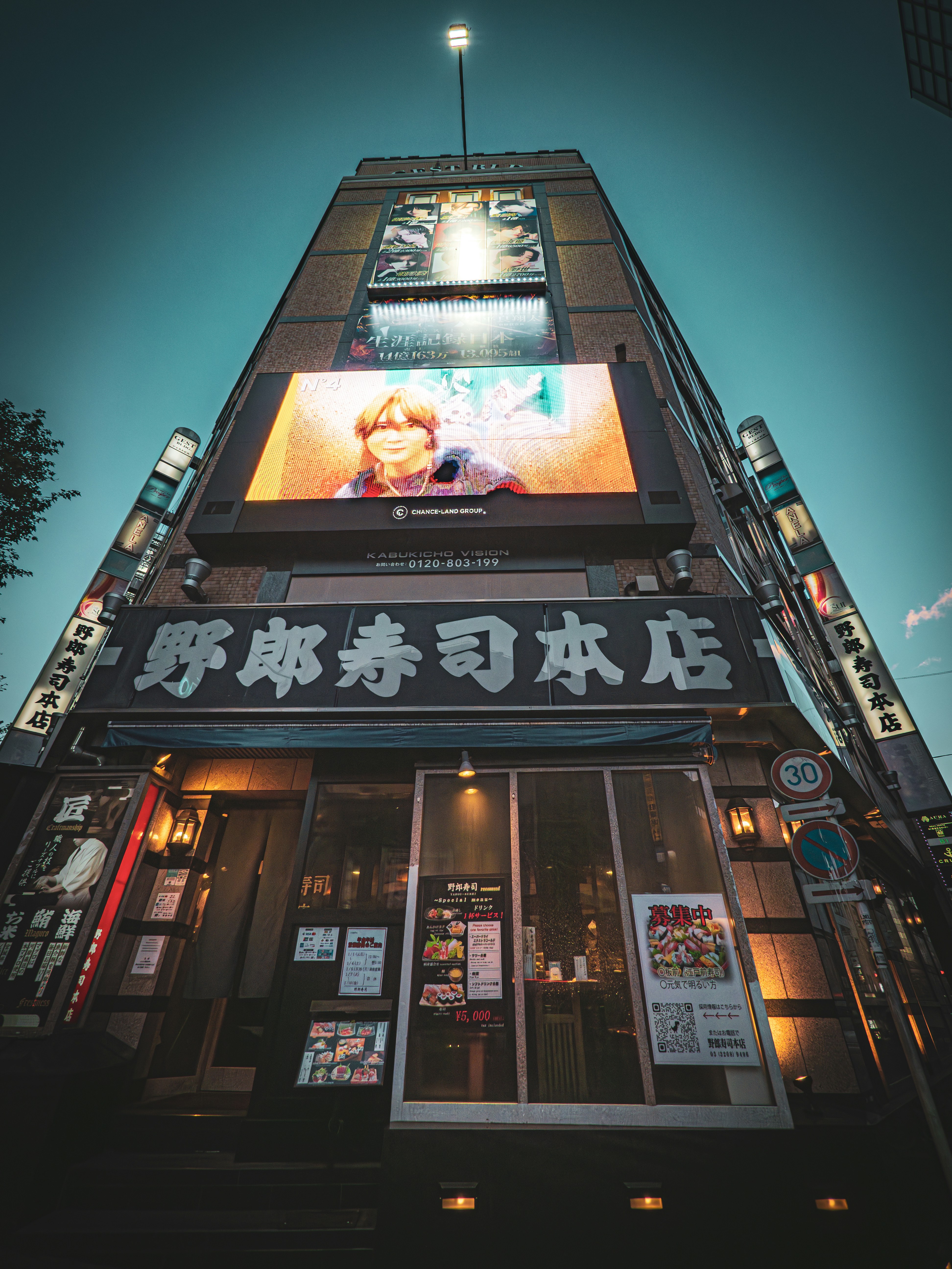 A very tall building with a lot of signs on it