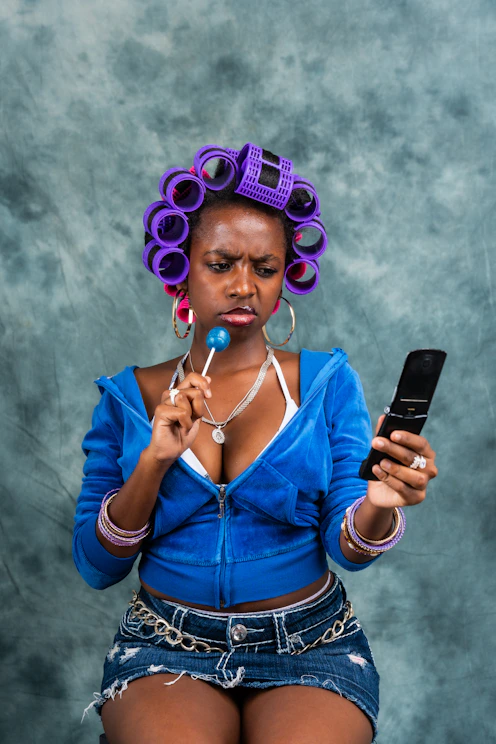 A woman with a cell phone and curlers on her head