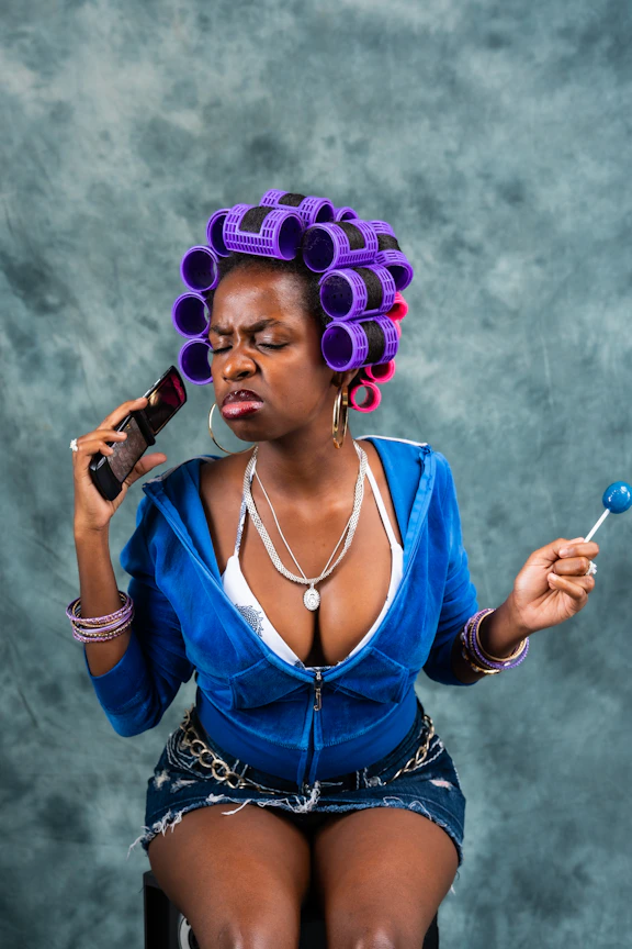A woman in a chair with a purple hair curl on her head