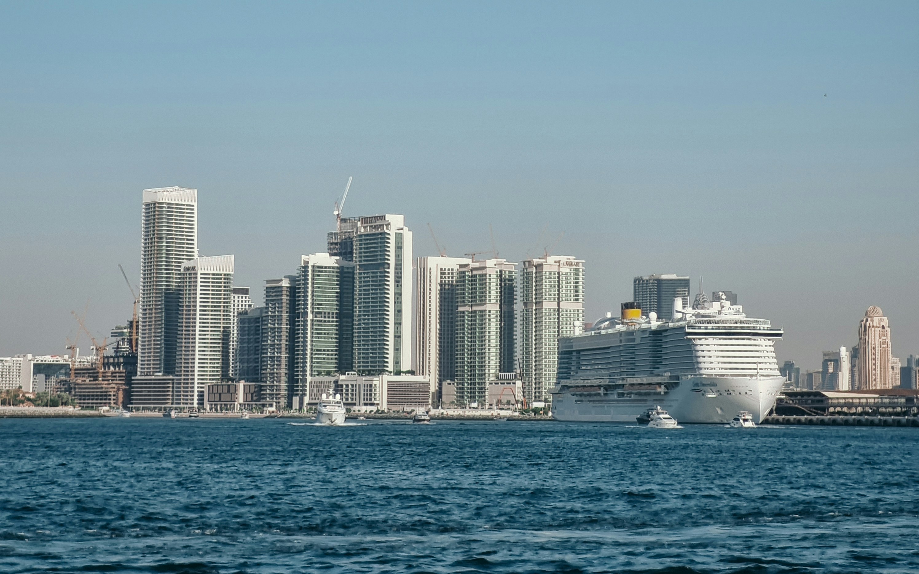 A cruise ship in the water near a city