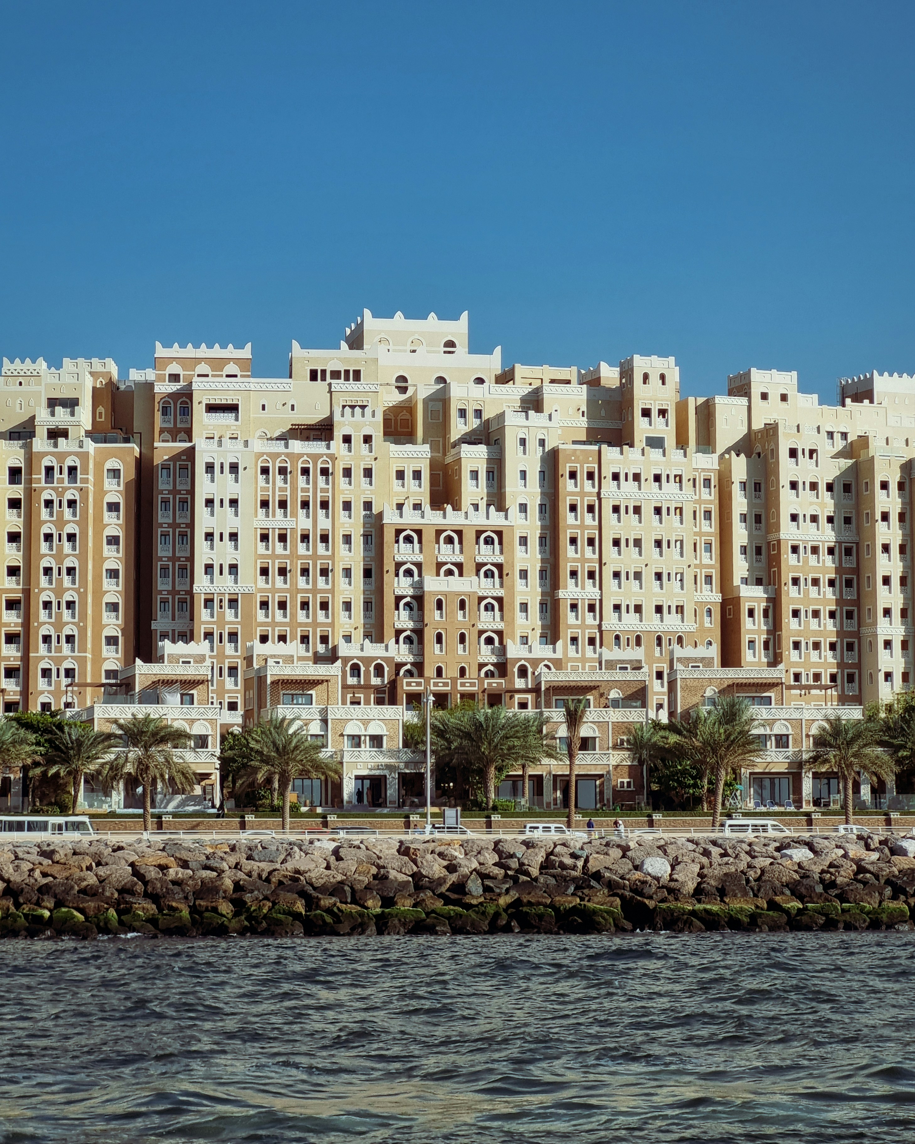 A very tall building next to a body of water