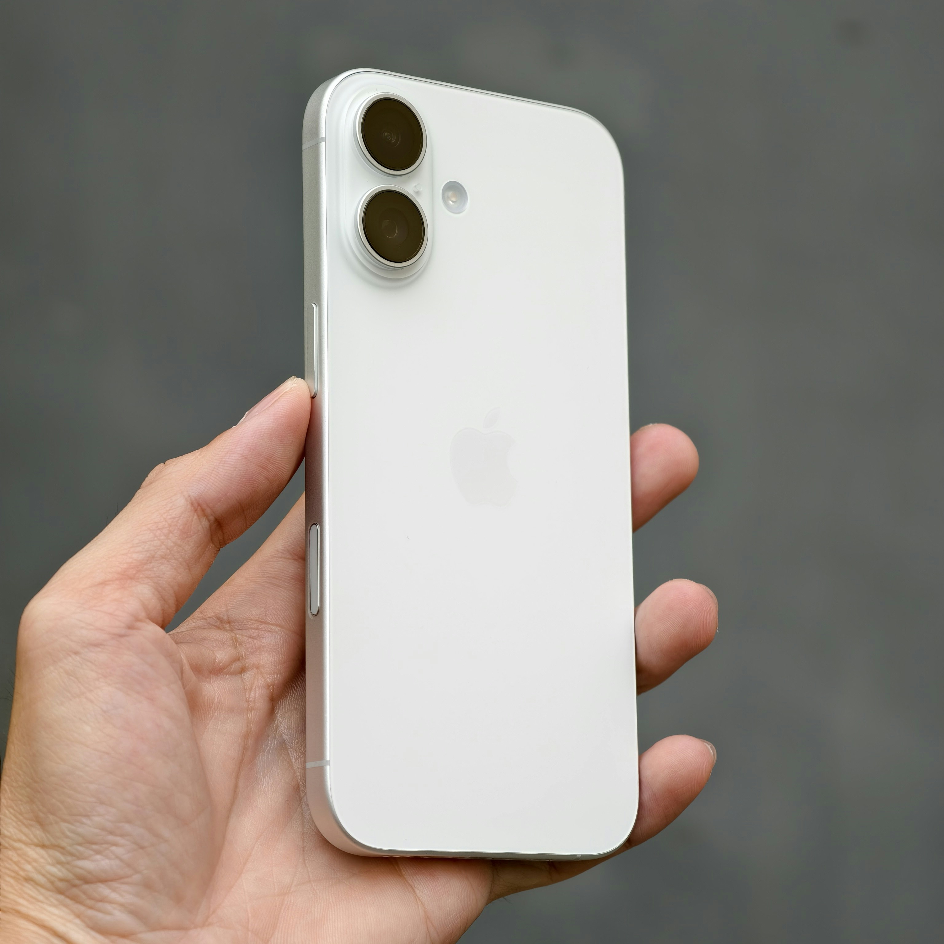 A person holding a white iPhone in their hand
