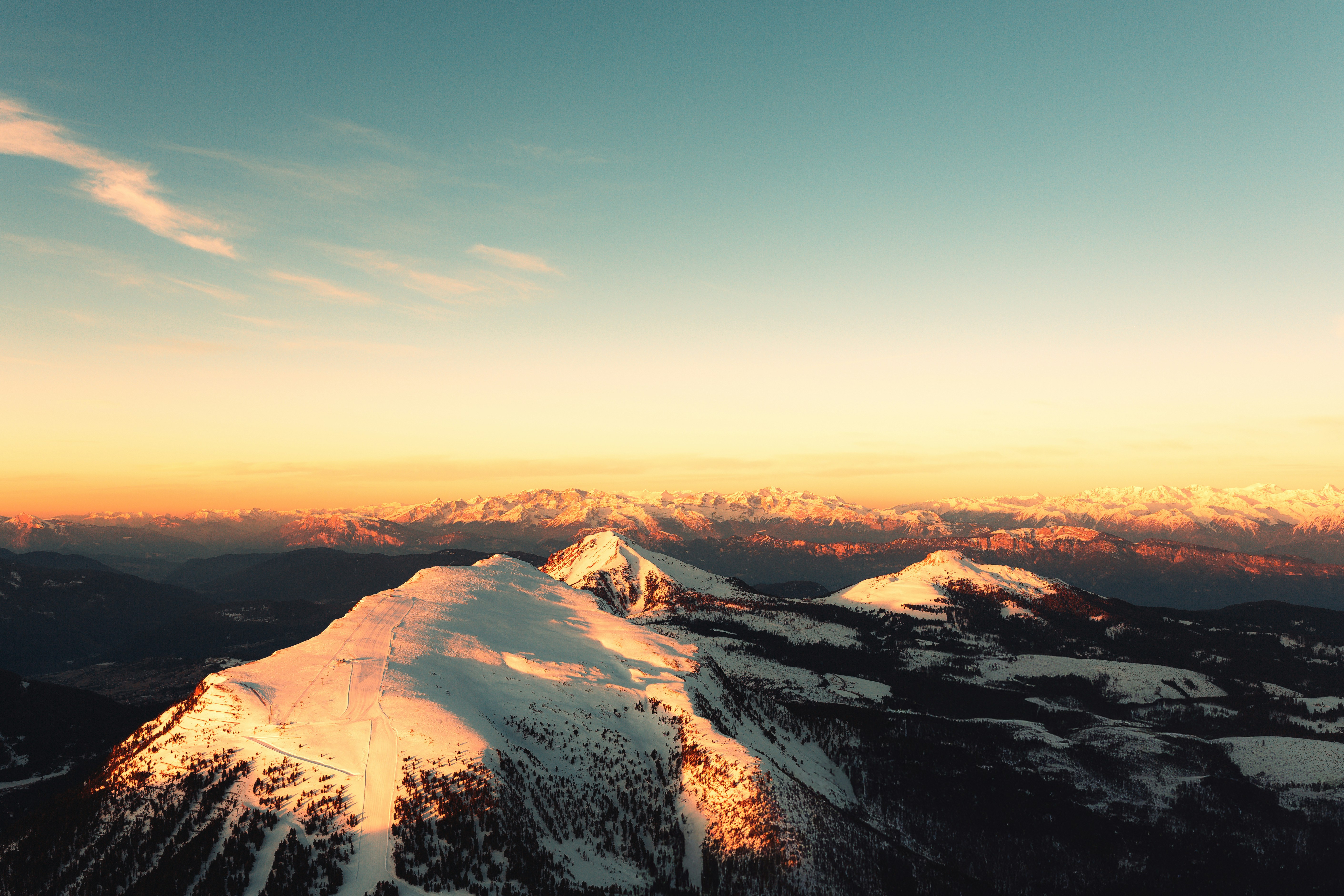 A view of a snow covered mountain at sunset
