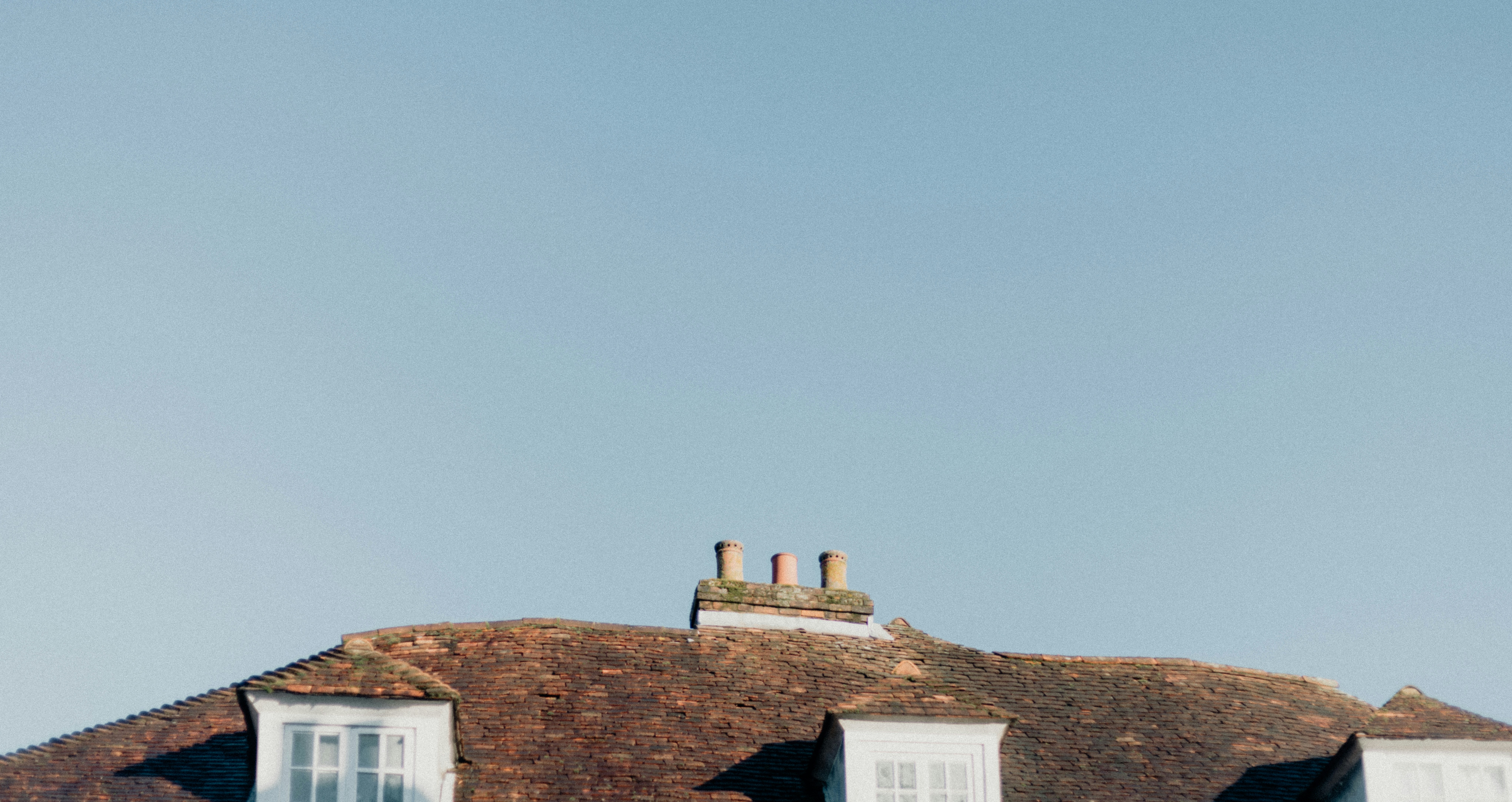 A couple of white windows sitting on the side of a building
