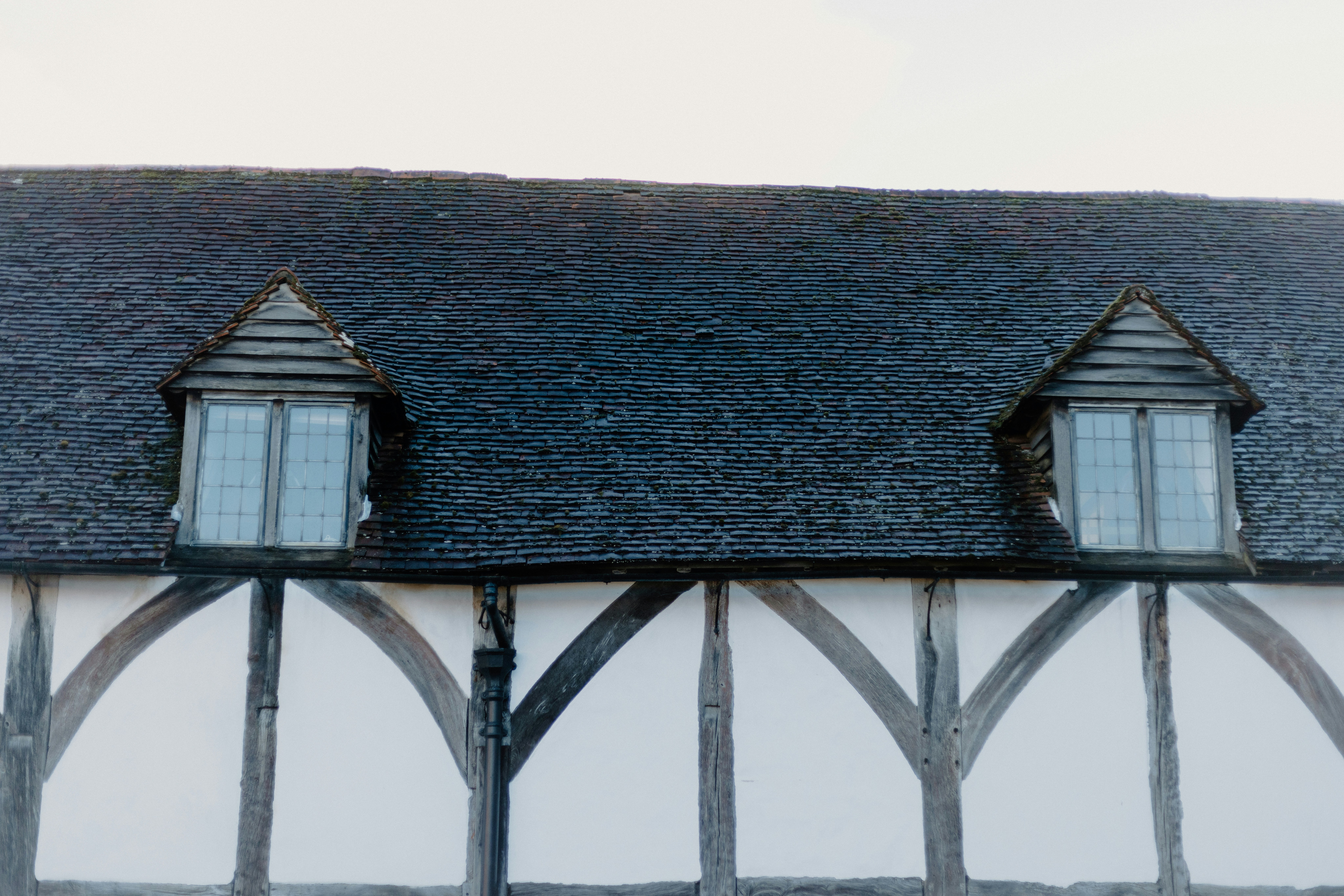 A black and white building with two windows and a black roof