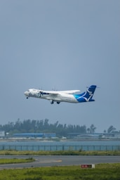 A large passenger jet flying over a runway