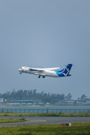 A large passenger jet flying over a runway