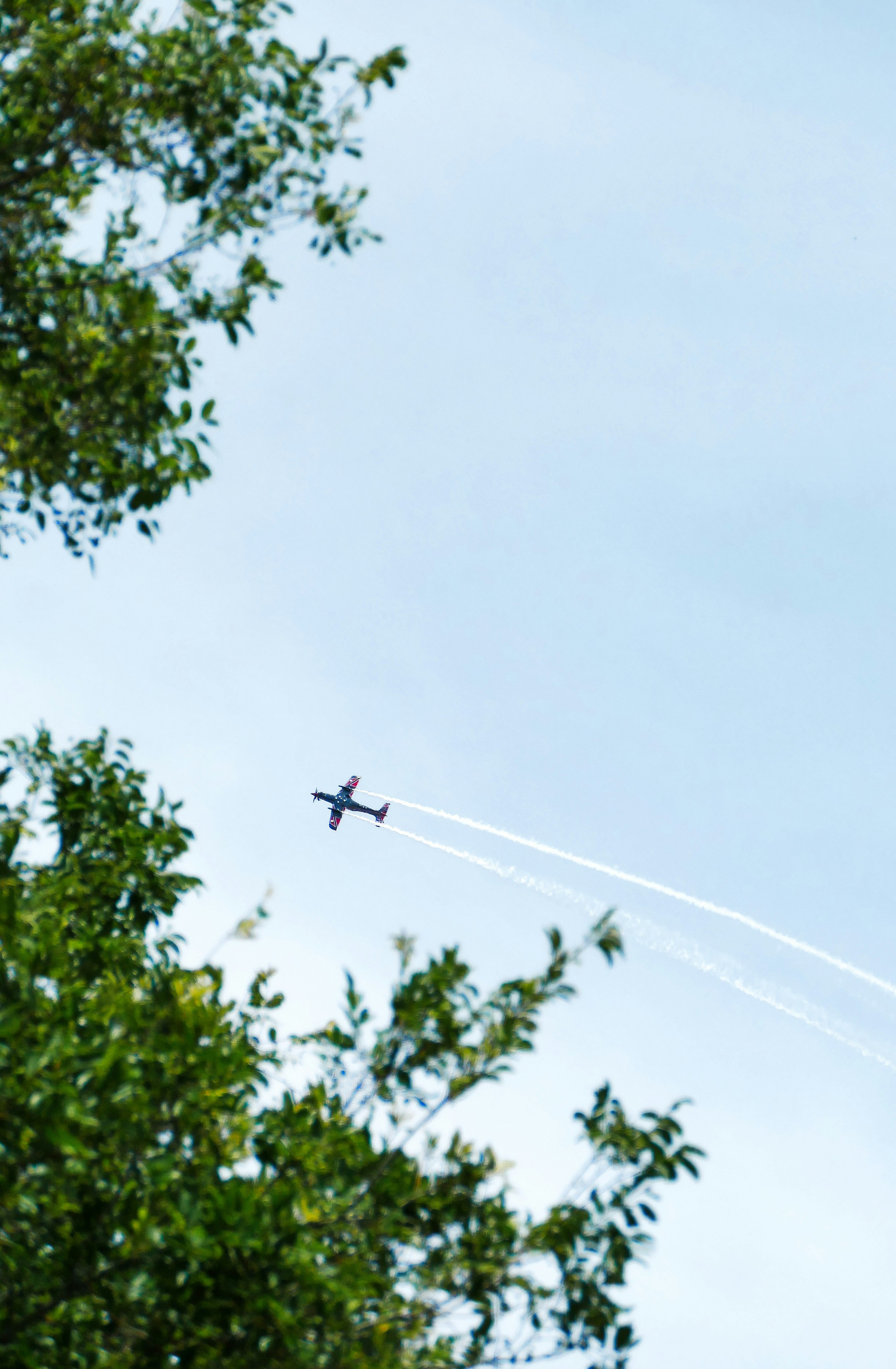 A small plane flying through a blue sky