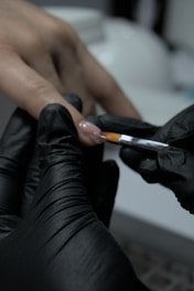 A person in black gloves holding a cigarette