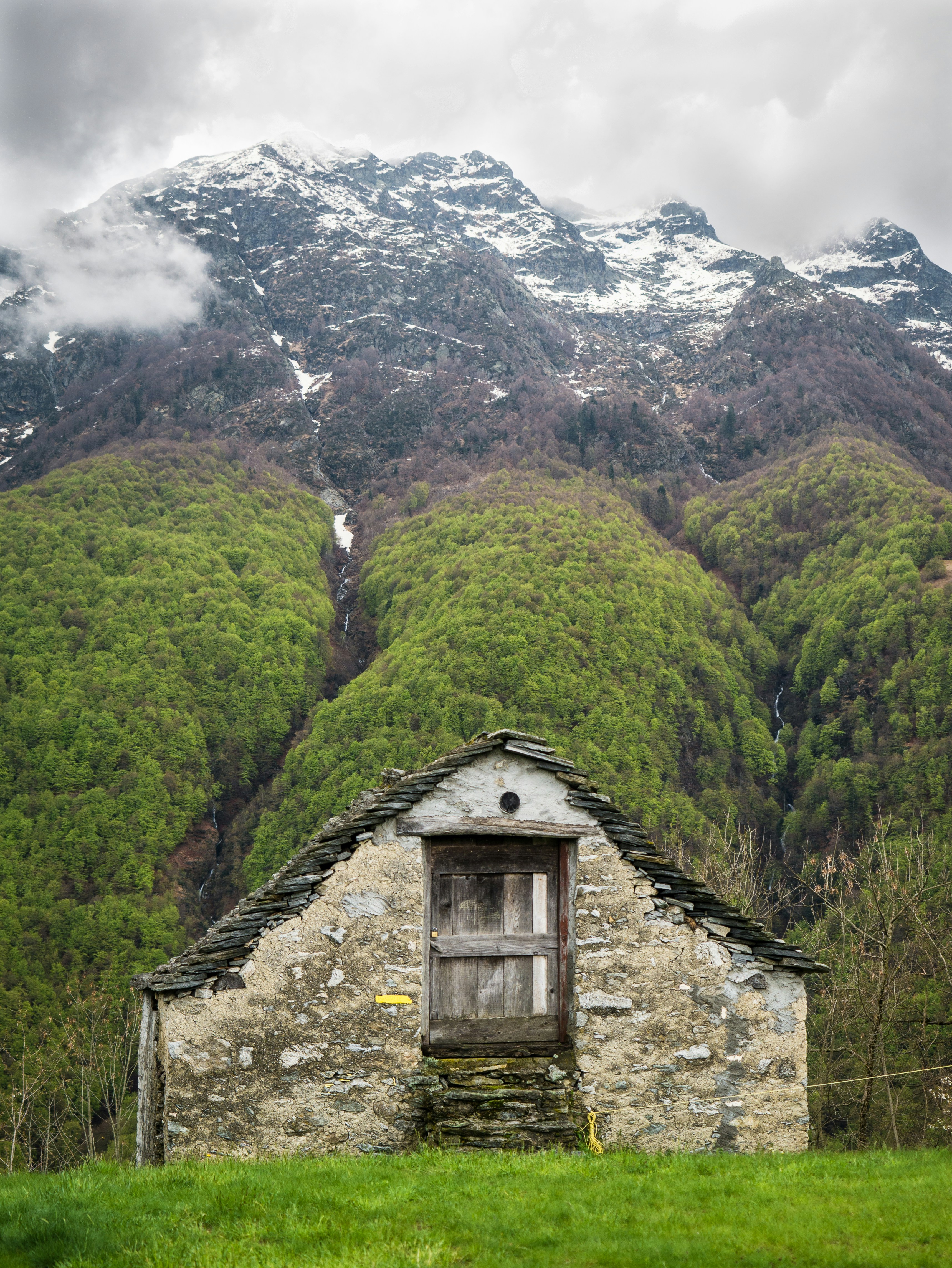 An old stone building with a mountain in the background