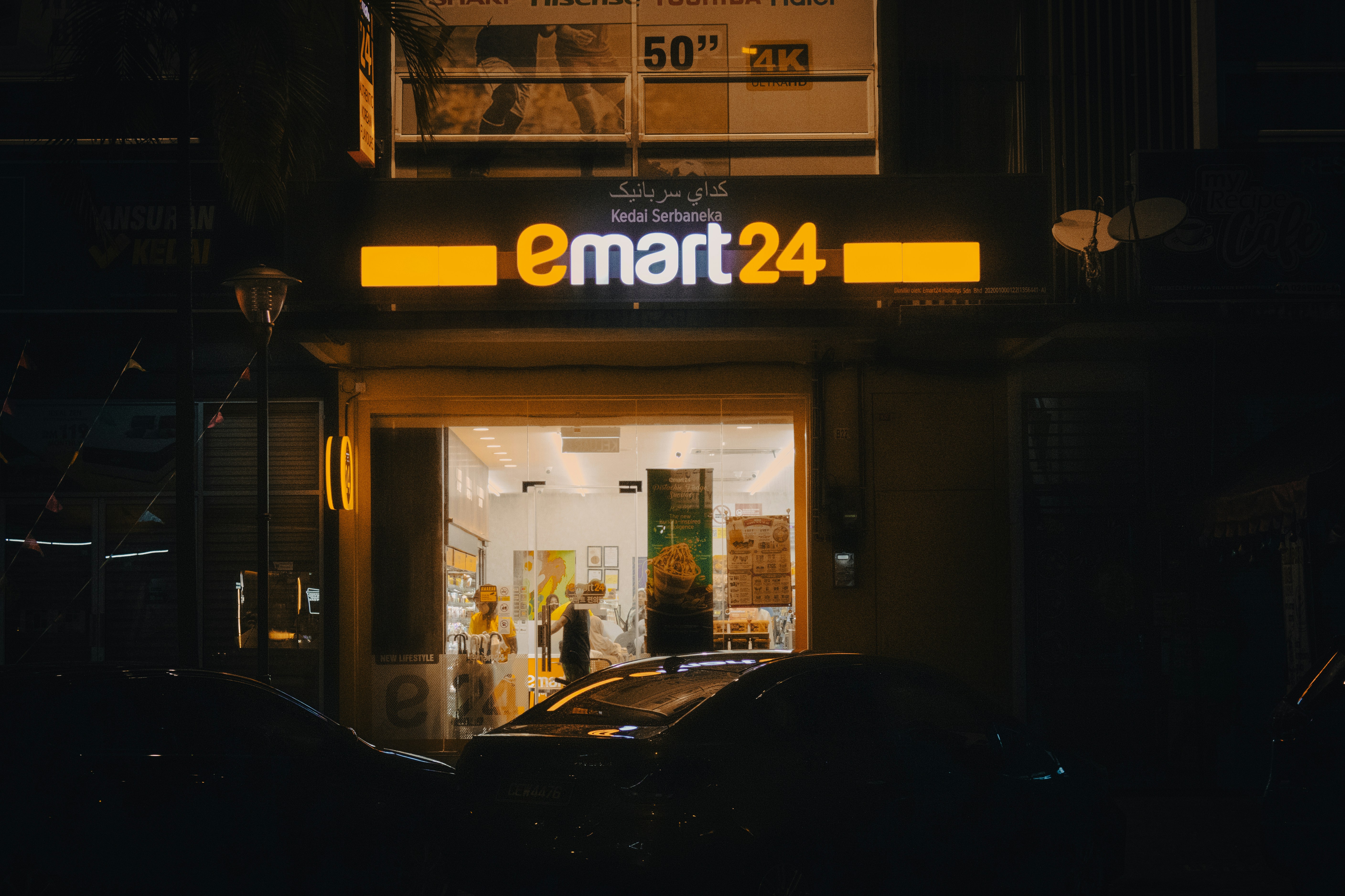 A car parked in front of a store at night