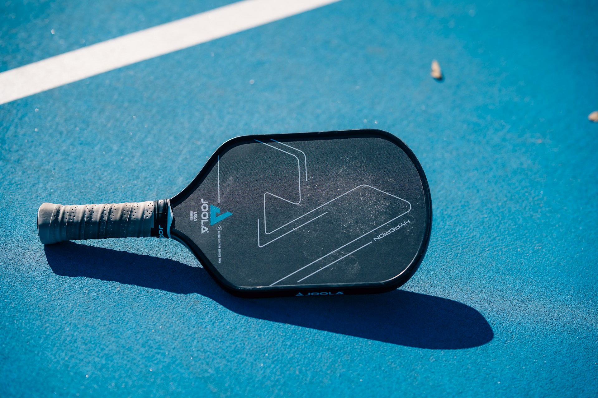 A close up of a tennis racket on a tennis court