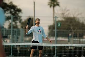 A man holding a tennis racquet on top of a tennis court