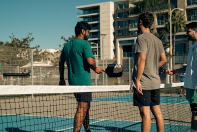 A group of men standing on top of a tennis court