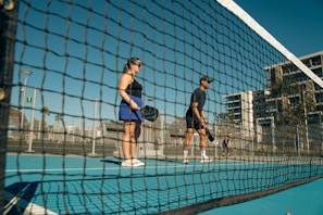 A couple of men standing on top of a tennis court