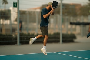 A man holding a tennis racquet on top of a tennis court