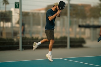 A man holding a tennis racquet on top of a tennis court