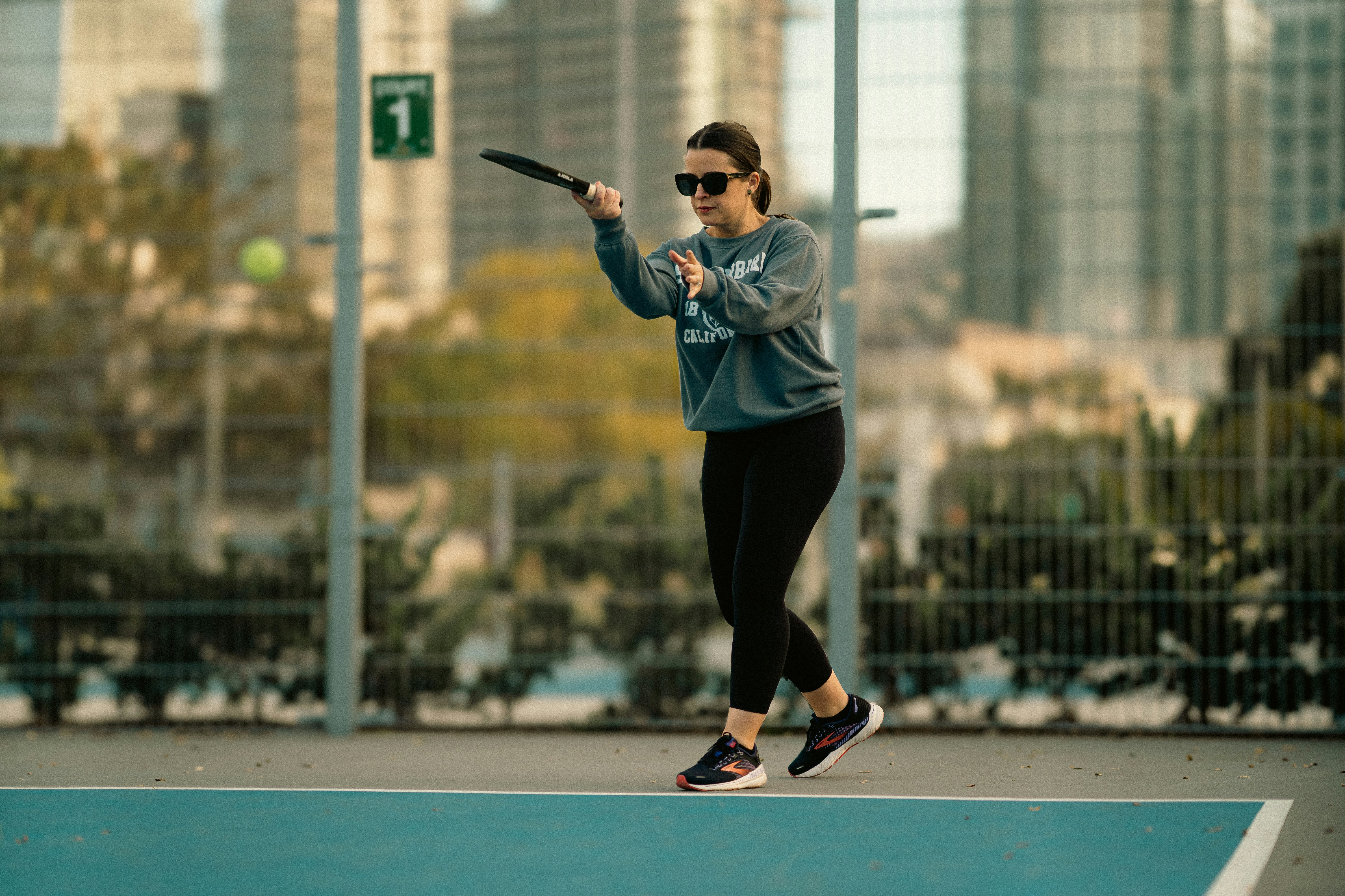 A woman swinging a tennis racquet on top of a tennis court