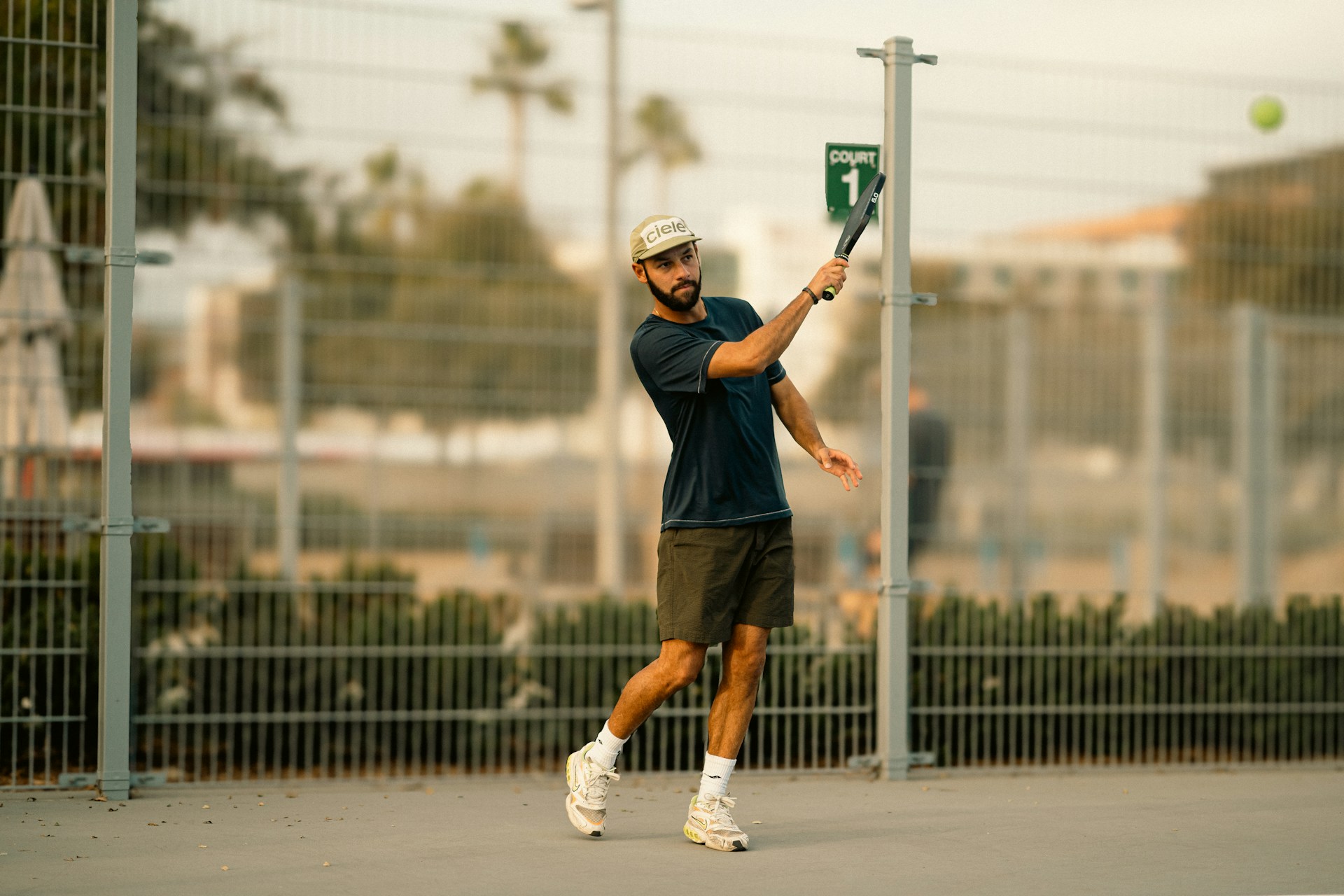 A man swinging a tennis racquet at a tennis ball