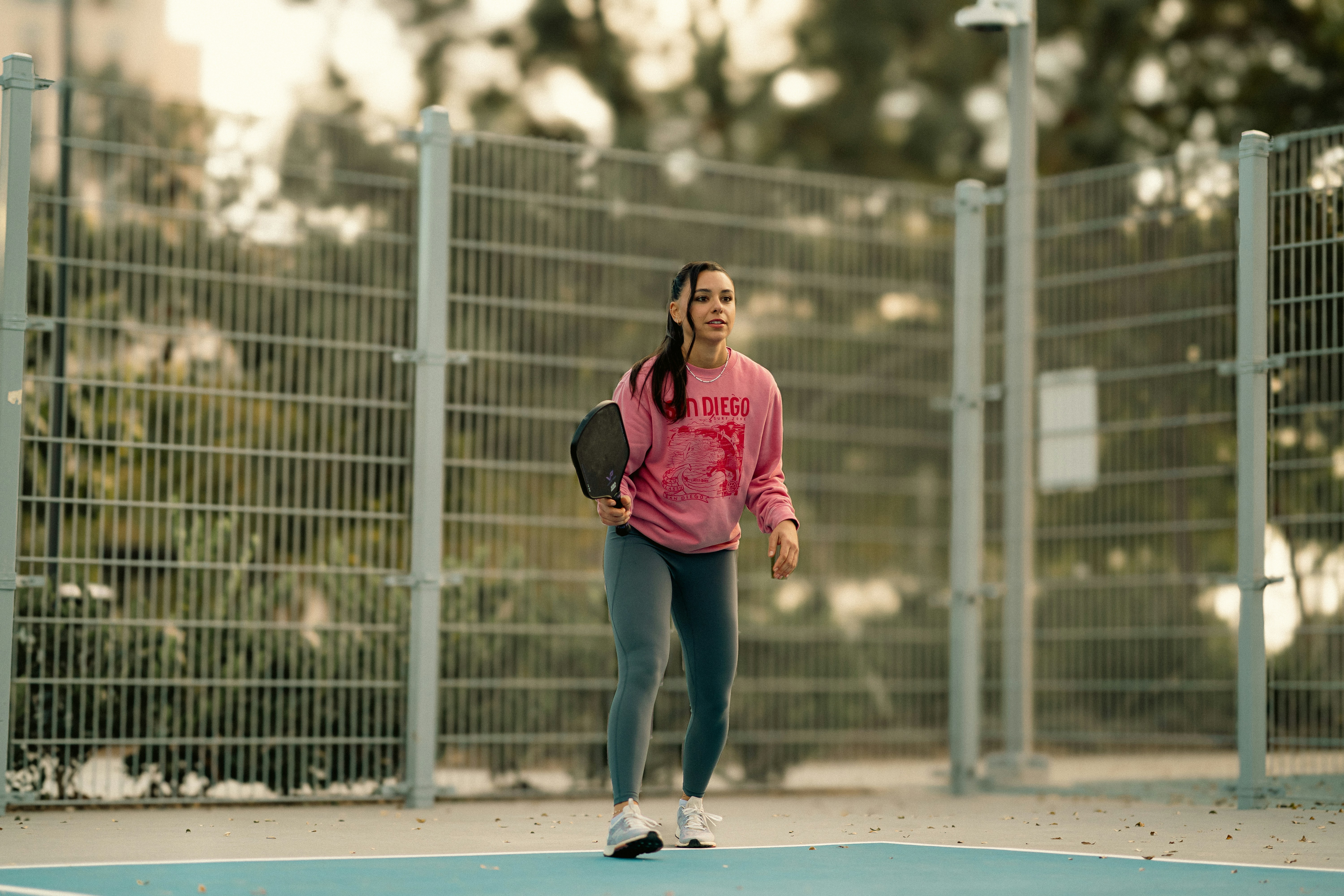 A woman in a pink shirt is playing tennis