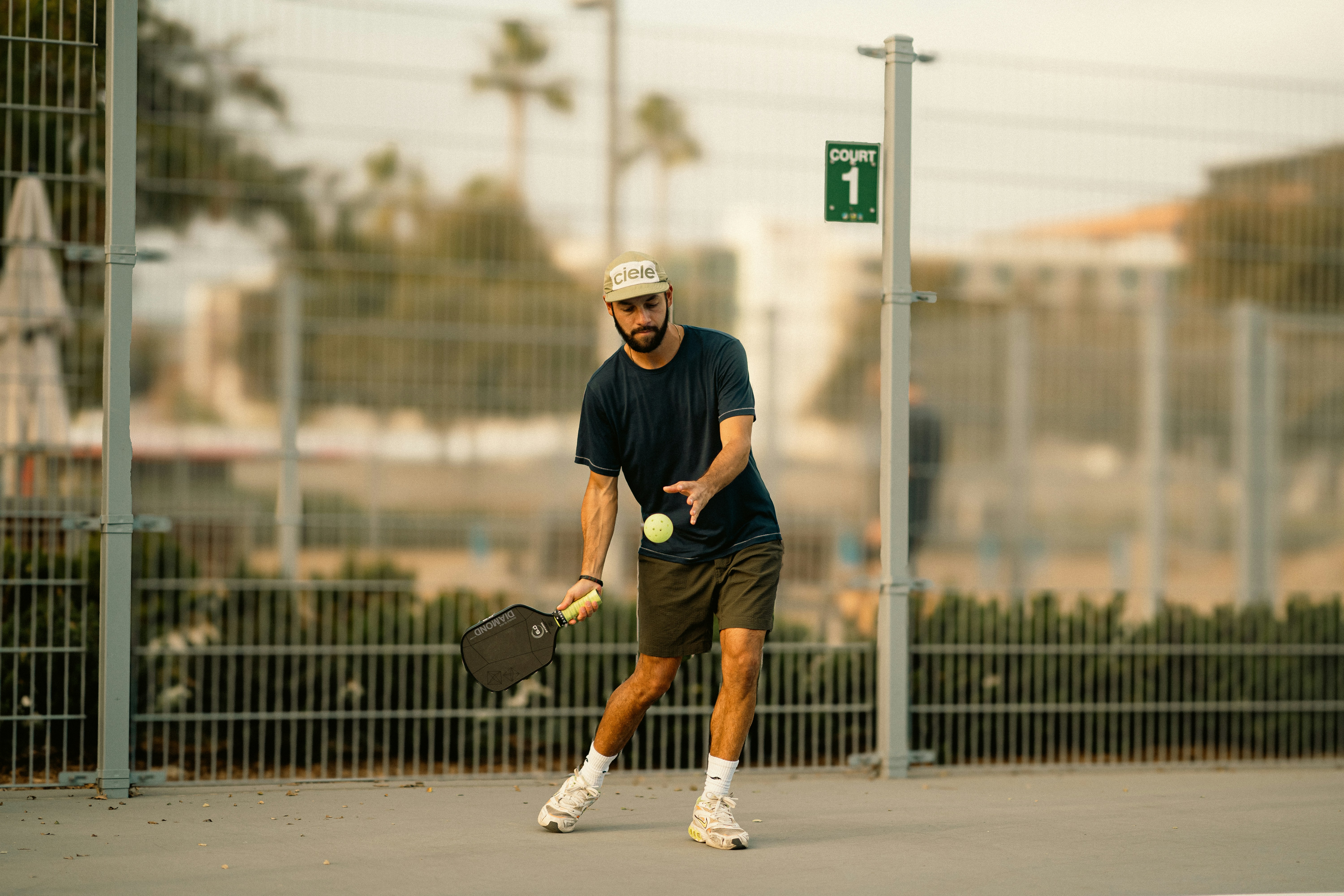 A man holding a tennis racquet on top of a tennis court