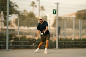A man holding a tennis racquet on top of a tennis court