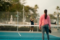 Two people playing tennis on a tennis court