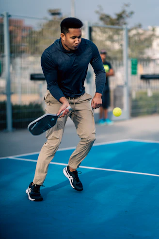 A man holding a tennis racquet on top of a tennis court