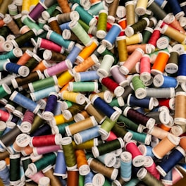 A bunch of spools of thread sitting next to each other