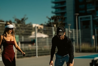 A man standing next to a woman holding a tennis racquet