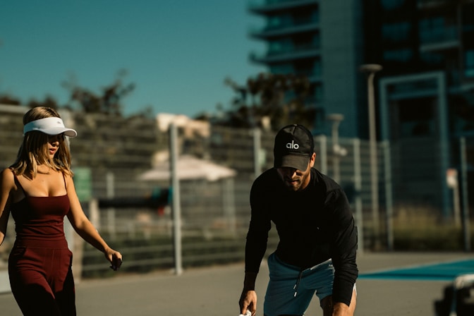 A man standing next to a woman holding a tennis racquet