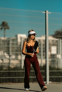 A woman is standing on a skateboard in a parking lot