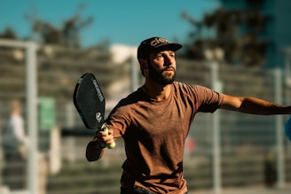 A man holding a tennis racquet on top of a tennis court