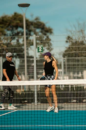 A couple of people that are standing on a tennis court