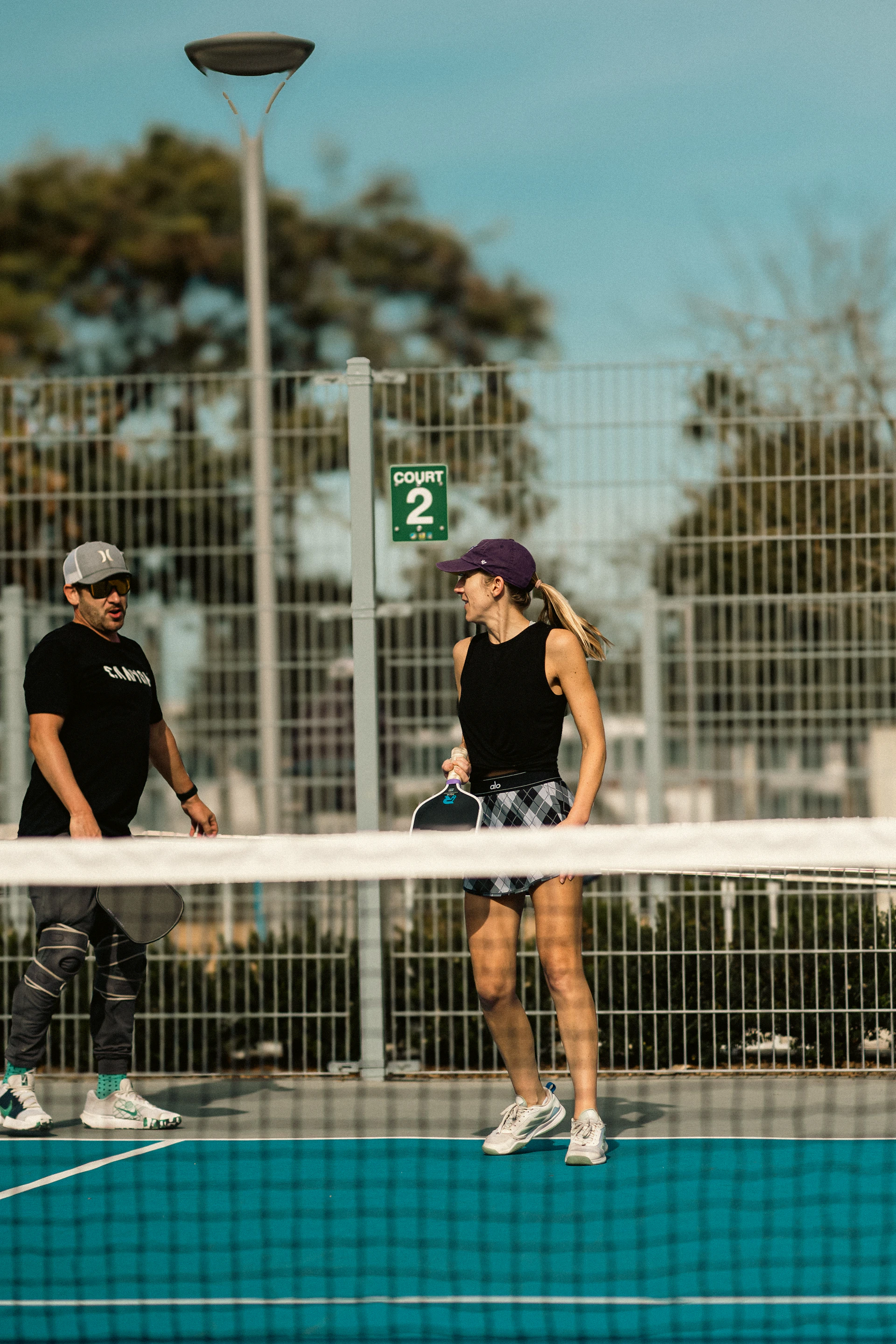 A couple of people that are standing on a tennis court