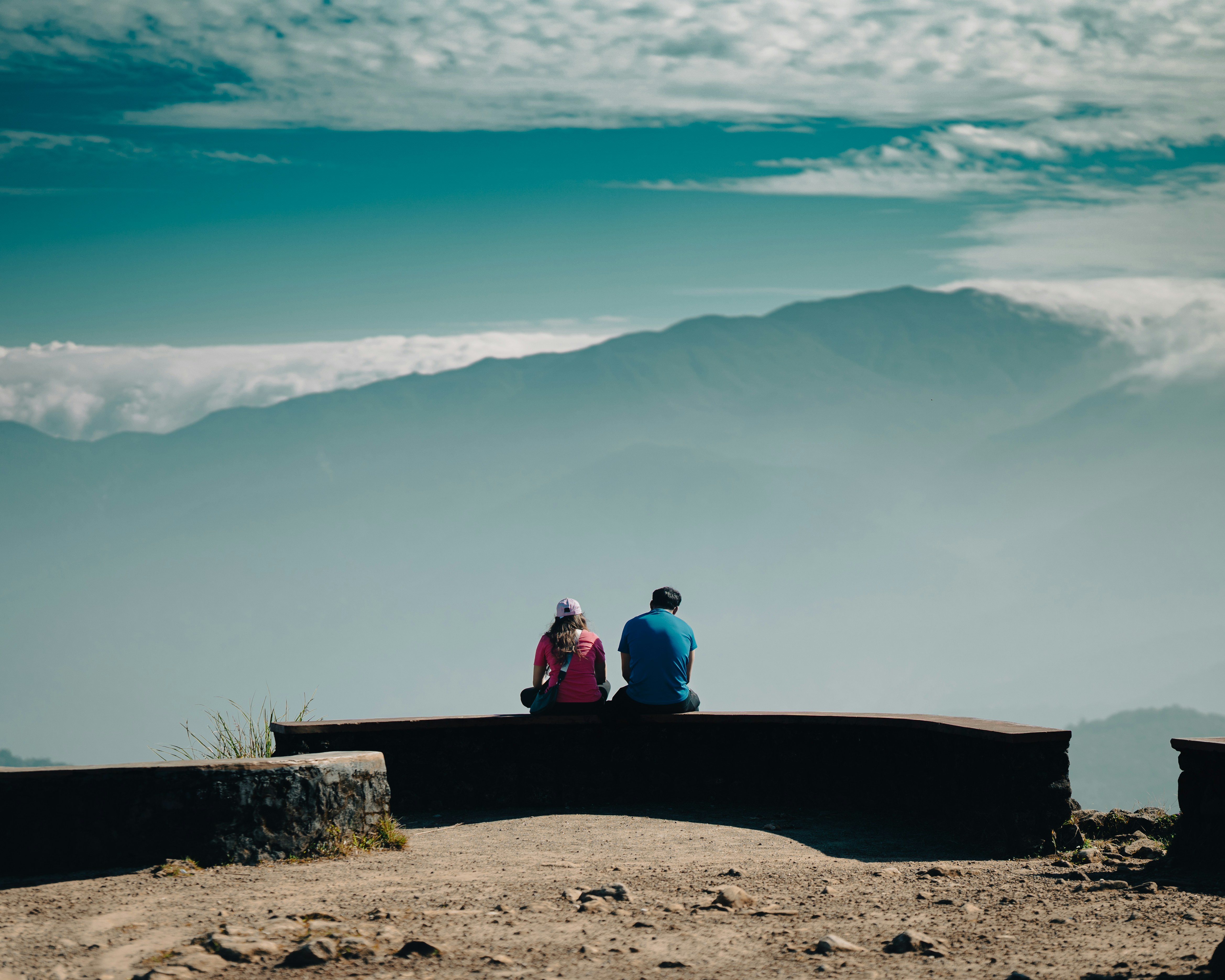 A couple of people sitting on top of a bench