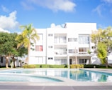 A swimming pool in front of a white building