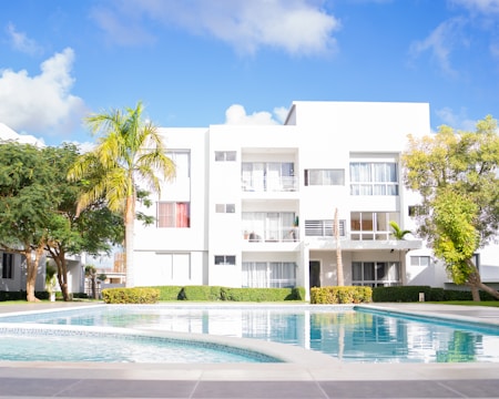 A swimming pool in front of a white building