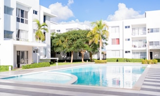 A swimming pool in front of a white building