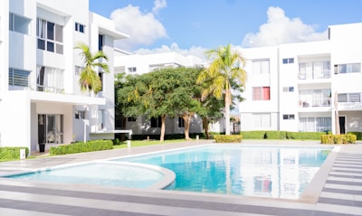A swimming pool in front of a white building